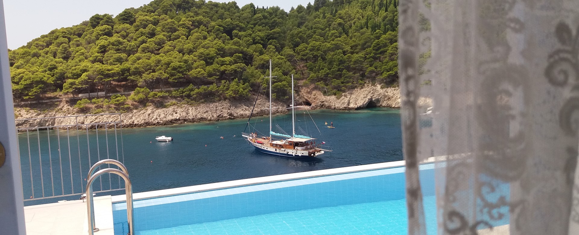 View from inside Villa Panorama looking out into the bay with yacht and private pool