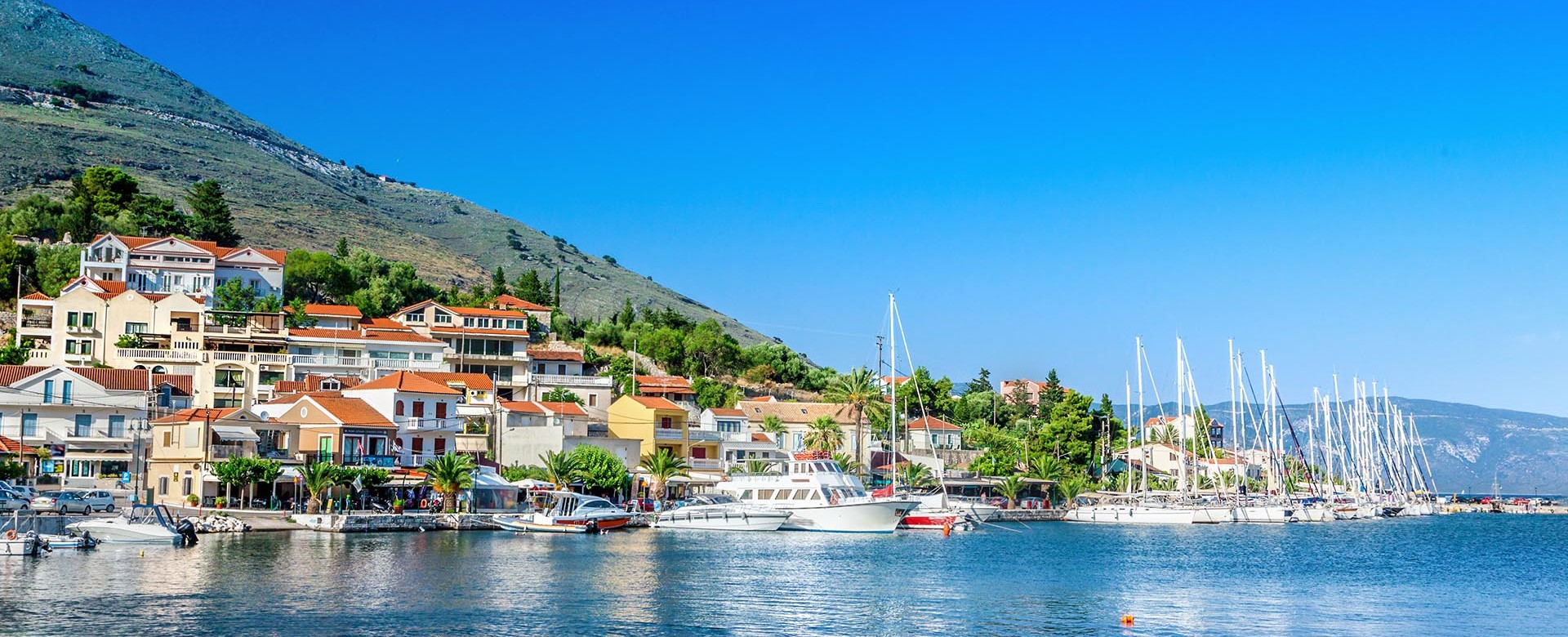 Agia Efimia waterfront with moored yachts and mountains in the distance, Kefalonia, Greek Islands