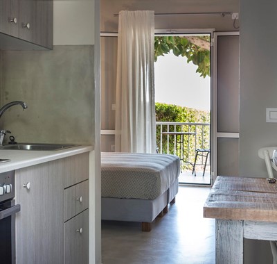 Kitchen, dining and views toward the sea through the French doors inside Beachfront Suite No1, Lourdata, Kefalonia