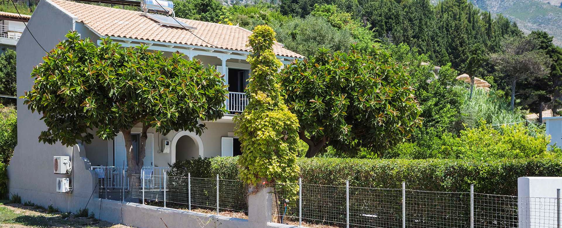 Lush green gardens and planting with the mountains as a backdrop at Beachfront Suites, Lourdata, Kefalonia