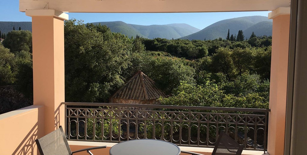 Share a holiday drink with mountain views on the veranda at Casa Angela, Melissani Apartments, Karavomilos, Kefalonia, Greek Islands