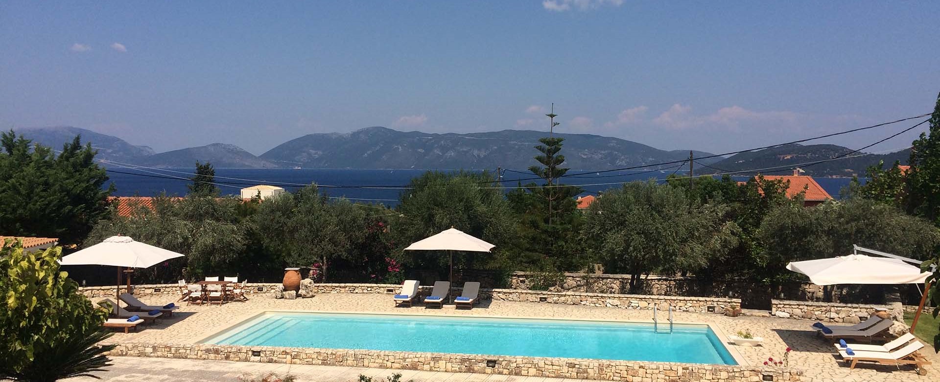 Pool Sun loungers sea and mountain views at Casa Angela, Melissani Apartments, Karavomilos, Kefalonia, Greek Islands