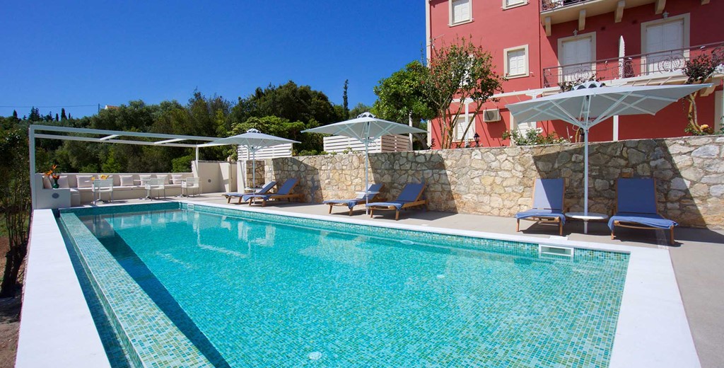 Pool and sun beds ready for a long holiday sunbathing outside Magnolia Apartments, Fiscardo, Kefalonia, Greek Islands