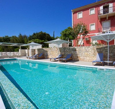 Pool and sun beds ready for a long holiday sunbathing outside Magnolia Apartments, Fiscardo, Kefalonia, Greek Islands