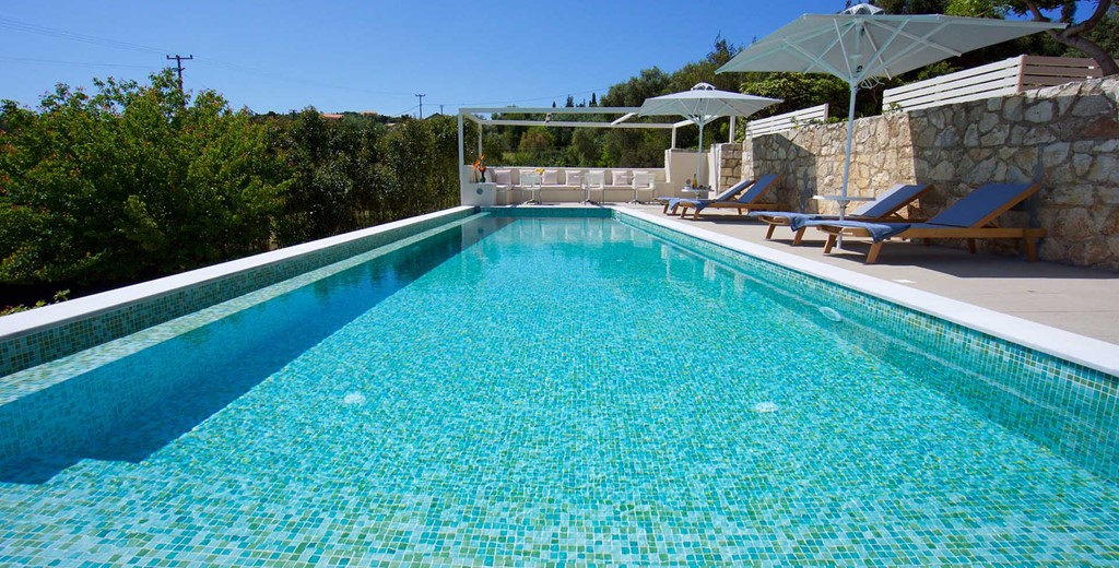 The pool, sun loungers and seating area outside Magnolia Apartments, Fiscardo, Kefalonia, Greek Islands