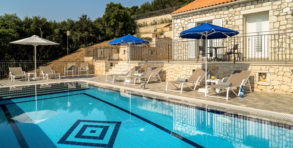 Family friendly poolside setting with loungers and umbrellas at Villa Gionis Fiscardo, Kefalonia, Greek Islands