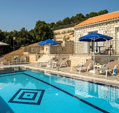 Family friendly poolside setting with loungers and umbrellas at Villa Gionis Fiscardo, Kefalonia, Greek Islands