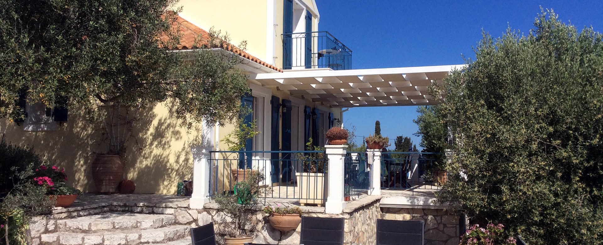 Traditional sun terrace with mature olive trees at Villa Lithia, Fiscardo, Kefalonia, Greek Islands