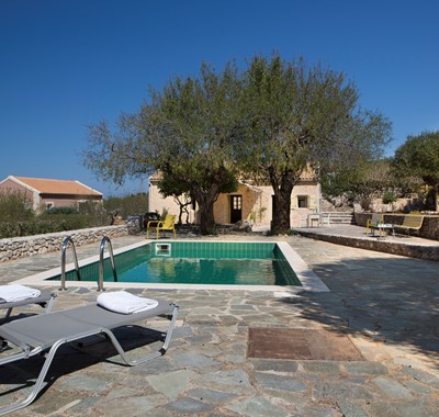 Pool, sun loungers and trees make a great escape outside Lemoni Cottage, Fiscardo, Kefalonia