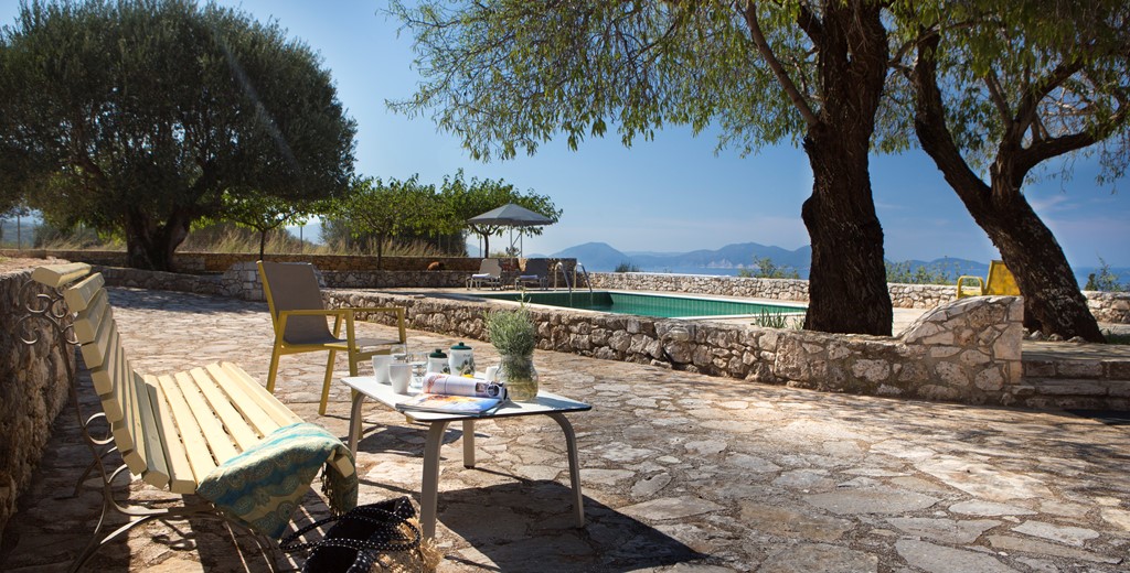 Bench to relax on during the afternoon sun with trees for shade outside Lemoni Cottage, Fiscardo, Kefalonia