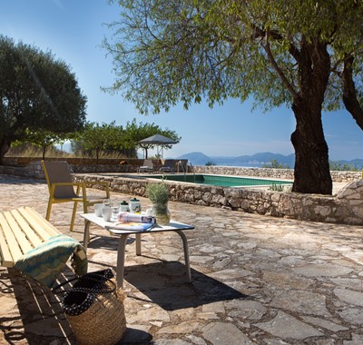 Bench to relax on during the afternoon sun with trees for shade outside Lemoni Cottage, Fiscardo, Kefalonia