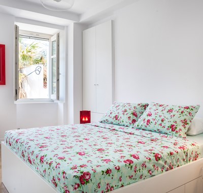Spacious bedroom with double bed and open window inside Palm House Harbourfront Mansion, Agia Efimia, Kefalonia, Greek Islands