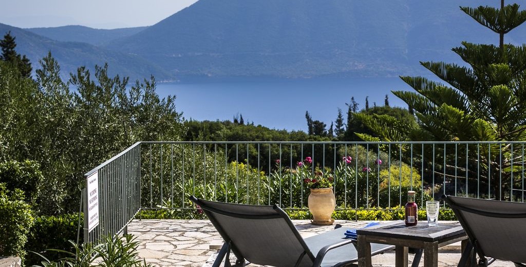 Sun beds on the terrace surrounded by lush gardens around Villa Cypress, Fiscardo, Kefalonia, Greek Islands