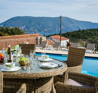 Al fresco dining beside the pool with a view of the cost and mountains outside Villa Pelagia, Fiscardo, Kefalonia, Greek Islands