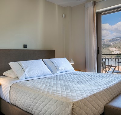 Bedroom with large double bed and access to the balcony with views across Argostoli, Kefalonia, Greek Islands